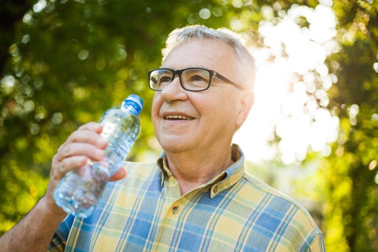 Senior man enjoying the benefits of drinking water on a hot summer day