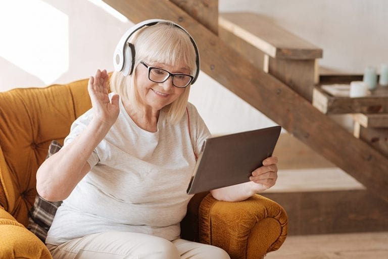Elderly woman enjoying a tablet and headphones