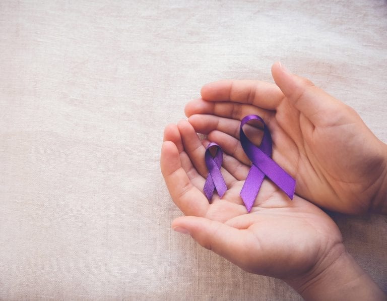 Person holding Alzheimer's awareness ribbon