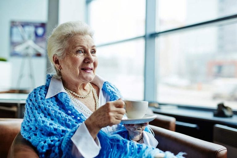 Elderly woman enjoying coffee