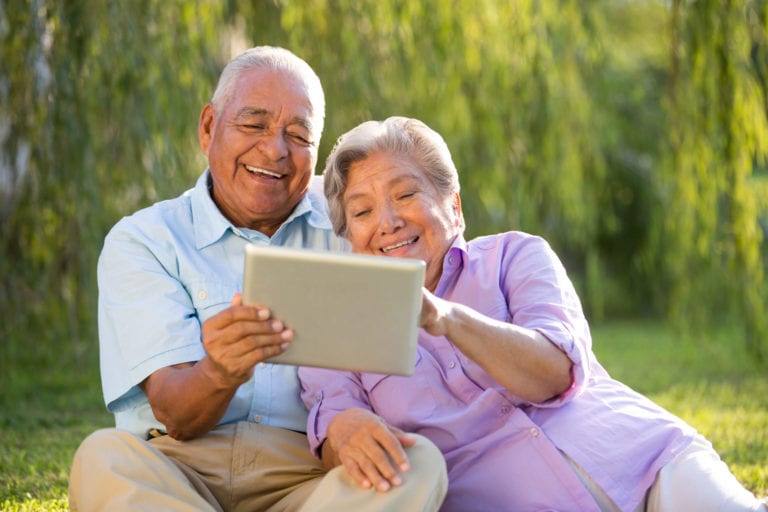 happy Latin couple with a tablet
