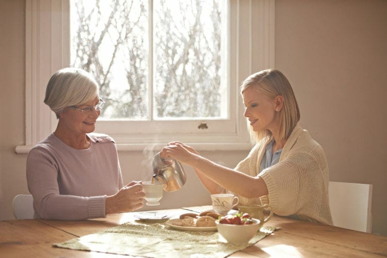 women and her elderly mother having tea